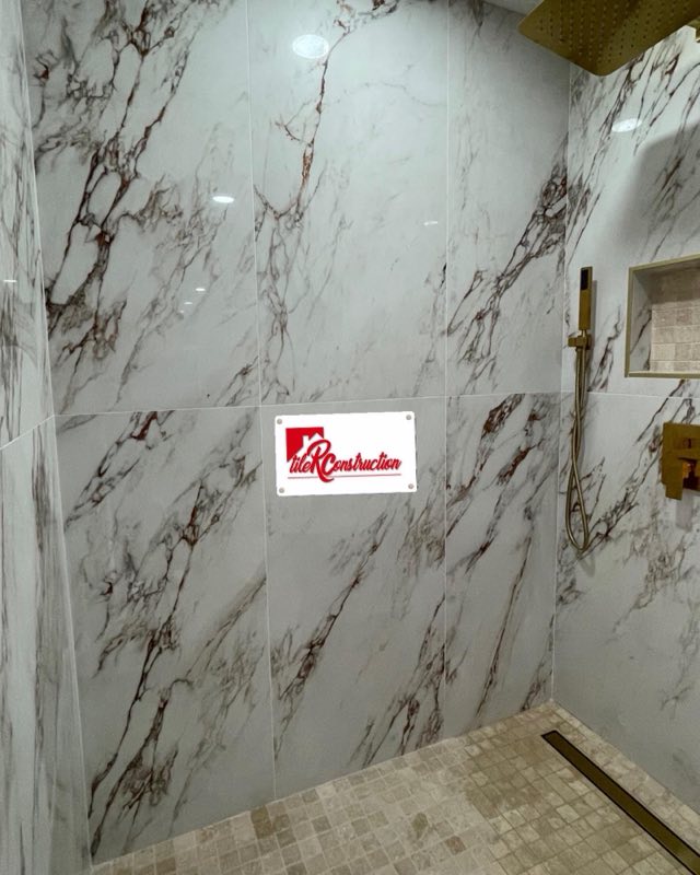 Marble slab shower walls with gold fixtures